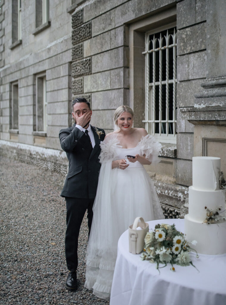 Brautpaar steht vor Hochzeitstorte