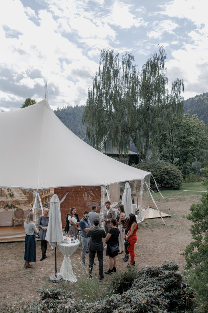 Gäste vor einem Zelt während einer Hochzeit