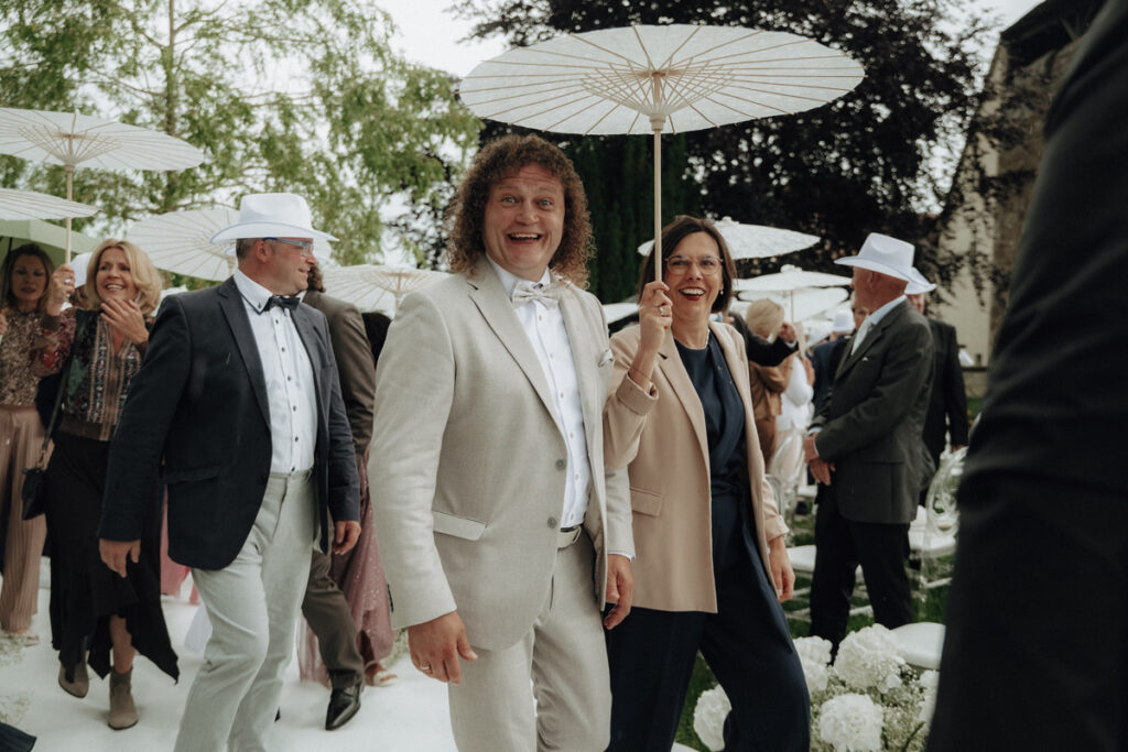 Wedding Guests walking in the rain with umbrellas