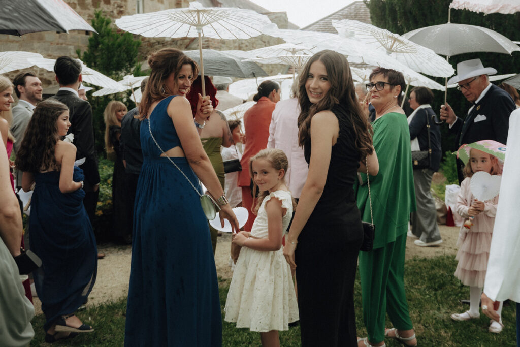 Wedding Guests walking in the rain with umbrellas