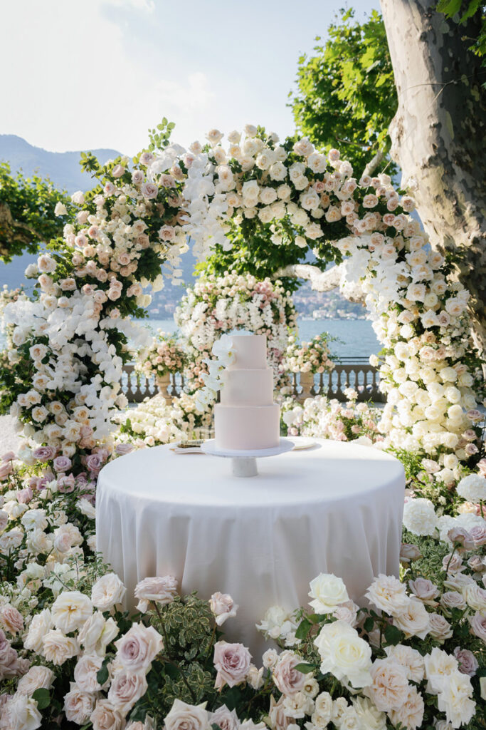 Wedding Cake presentation in between floral archs at Lake Como