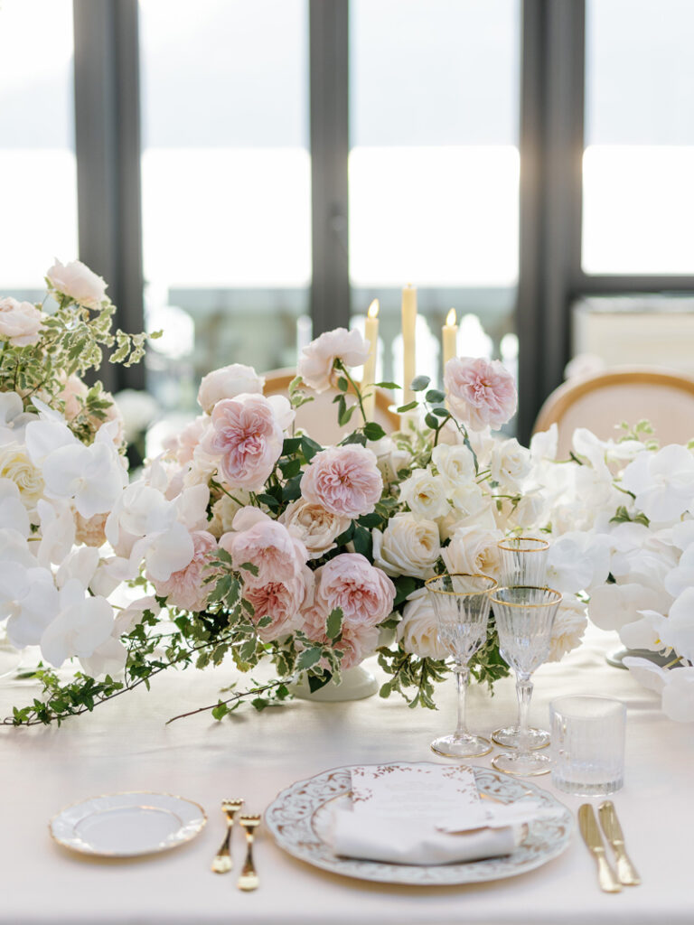 Dinner Decoration at the Greenhouse - Mandarin Oriental, Lake Como. Charger Plate with Napkin, Menu Card and Name Card, golden Cutlery, Floral Arrangement and LED Tap Candles