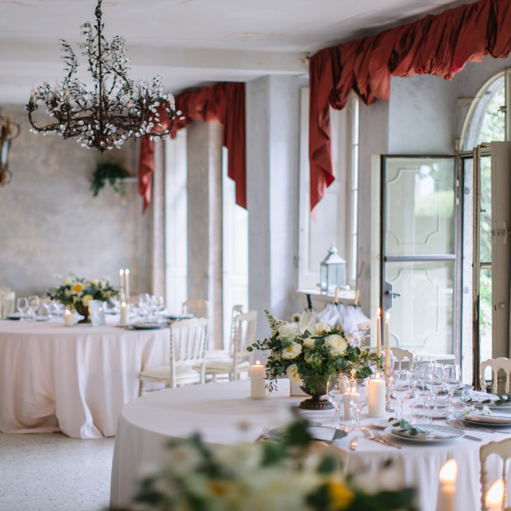 Picture of the Dinning Room of Villa Regina Teodolina at Lake Como. You can see decorated dinning tables with light blush colored table linen, floral arrangements and tap candles.
