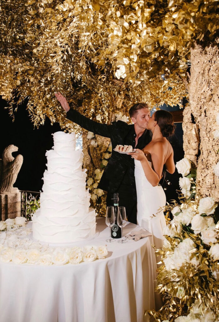 Couple after cutting the wedding cake, tasting the cake and kissing each other