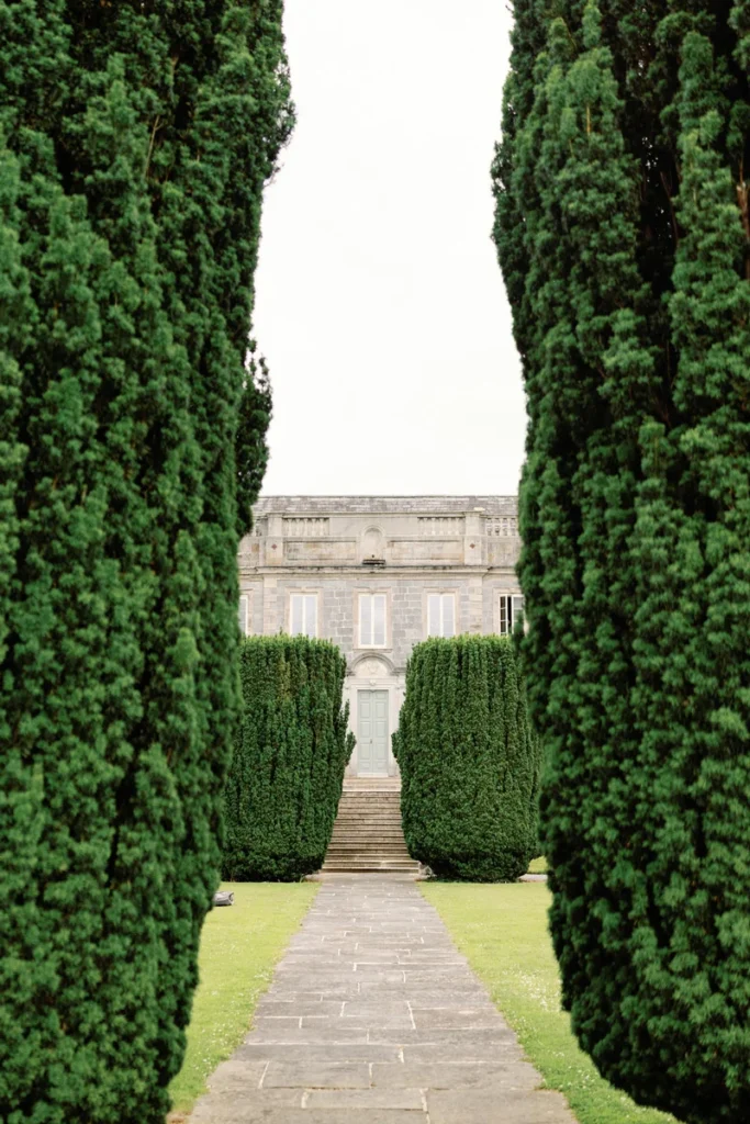 Blick durch die historische Baumallee auf das Portal und den Haupteingang des Herrenhauses Gloster House