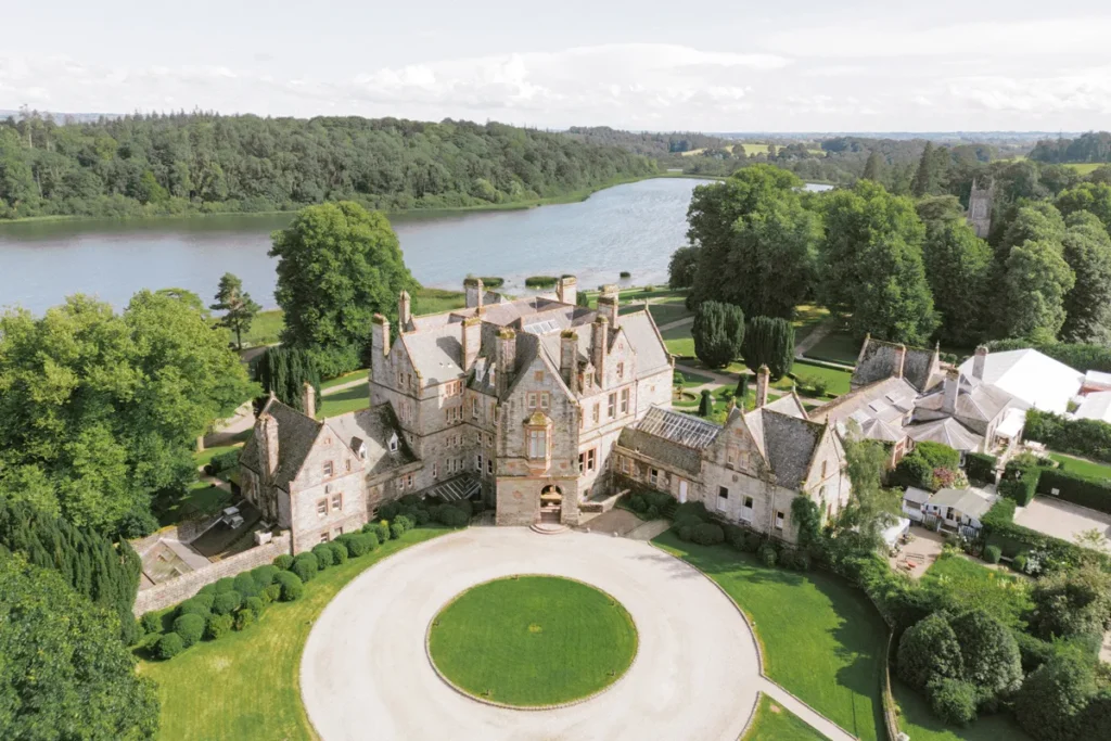 Luftaufnahme von Castle Leslie Estate mit dem ruhigen See im Hintergrund